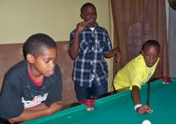From left, 11-year-old Heneas McLeod, 13-year-old Micah Tyson and Marquise Seres, 12, shoot pool at Friday Night Live. 